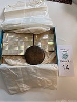 Box containing two mother of pearl cigarette cases and two powder compacts wrapped in tissue paper.