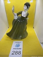 Front view of the Simone porcelain figurine showing the woman in a green dress holding a fan