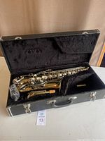 Open hard shell case showing saxophone body inside