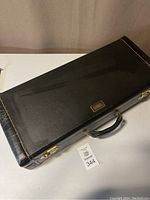 Closed black leatherette carrying case with gold-tone hardware and Selmer badge