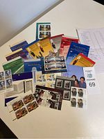 Image shows multiple Canadian stamp booklets spread out, each booklet with various history or place themes, partially full.