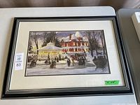 Framed print showing a winter ice skating scene with a large mansion and gazebo in the background.