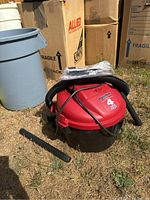 Shop Vac 4 Gallon Wet/Dry Vacuum with attached hose, extension nozzle on the ground next to it, outdoor setting.