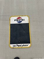 Photo of the front of the 1936 Pepsi menu board tin sign showing the Pepsi logo, black chalkboard area, yellow border and slogan at the bottom.