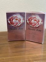 Two unopened boxes of Passion Rose perfume by Vince Camuto with floral packaging and volume details.