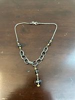 Sterling silver necklace with smokey quartz beads on a wooden surface, showing chain detail and beads.