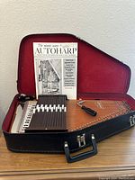 Vintage AutoHarp in black hard case with red lining, manual and tuning tool visible