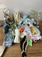 Overview of various vintage Barbie clothing items including knitted sweaters, lace skirts, stockings, and other garments.