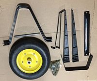Photo of wheelbarrow assembly kit showing wheel, frame components and assortment of mounting hardware.