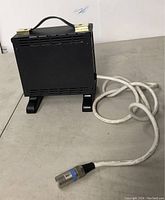 Full side view of the 24V wheelchair battery charger showing the black casing, power cable, and circular connector plug.