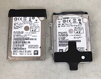 Top view of two laptop hard drives showing label stickers and model information.