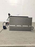 Top and side view of the audio amplifier showing the ribbed aluminum heat sink and attached wires.