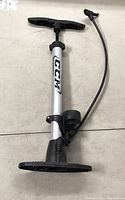 Full view of CCM floor bike pump with handle, barrel, base, and attached hose with valve connector.
