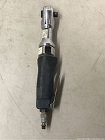 Top-down view of Mastercraft air ratchet showing black rubber grip, chrome ratchet head and lever switch on the side.