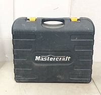 Closed view of dark gray Mastercraft carrying case with yellow latches and logo.
