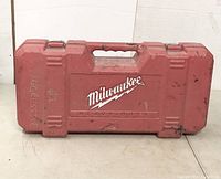 Red plastic closed carrying case with Milwaukee logo and text 'Heavy Duty'