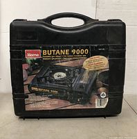 Closed carrying case with label showing the Portable Butane 9000 stove and usage info.