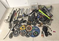 Wide view of the variety lot showing mobile tool chest with grinder, abrasive discs, wrenches, pliers, chisels, screwdrivers, hammer, and pneumatic or electric hand tools.