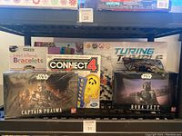 Photo showing Star Wars Captain Phasma and Boba Fett model kits, Connect 4 board game, and Turing Tumble kit on a shelf.