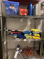 Shelf with handheld mini vacuum, jumper cables, microfiber cloths, cleaning gloves, extendable car brush, and gray car jack.