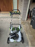Front view of the snowblower showing auger housing, chute, and folded handle
