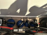 Four blue vinyl-coated kettlebells arranged horizontally beside exercise equipment mockup