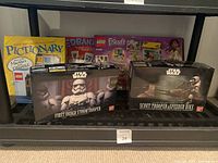 Photo showing two Bandai Star Wars model kits (First Order Stormtrooper and Scout Trooper with Speeder Bike) with LEGO Friends set and Pictionary game behind.