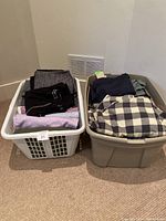 Two laundry baskets filled with folded men's clothes including shirts and sweaters