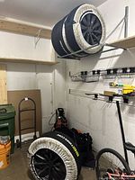 Four wheels with covers, two on shelf and two on floor