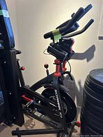 Side view of Schwinn IC4 spin bike showing frame, handlebars, flywheel and mounted dumbbells