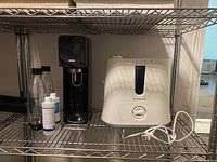 Honeywell humidifier and SodaStream soda maker on metal shelving with accessories visible