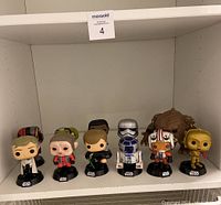 Full view of 8 Star Wars Funko Pop figures on a shelf showing characters including Luke Skywalker, R2-D2, Rebel pilot, Gamorrean Guard, and C-3PO.