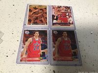Four basketball trading cards featuring Tom Gugliotta in protective sleeves laid out on a flat surface.