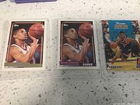 Three basketball trading cards showing Kevin Johnson in Suns uniforms, two close-up portraits, one in game action.