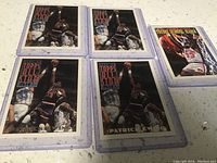 Five Patrick Ewing basketball trading cards laid out on a white surface, four with similar action shot design and one Topps Gold card.