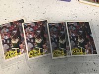 Four identical Shawn Kemp basketball trading cards arranged side by side on a light-colored countertop, showing the front image of the player in Seattle Supersonics uniform.
