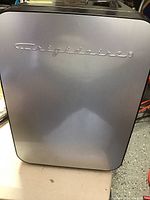 Front view of silver Frigidaire appliance with logo, placed on a white surface.