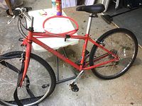 Orange Specialized Hardrock GX mountain bike without front tire on rim, showing side profile with visible branding on the frame.