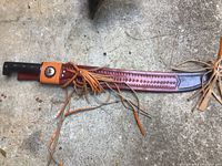 Front view of Imacasa machete sheathed in decorative leather with fringes.
