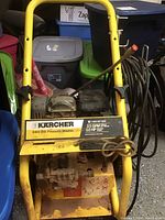 Front view of Karcher pressure washer showing brand label, engine, pump and yellow metal frame