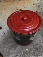 Closed view of the outside fire pit with the red lid on top.