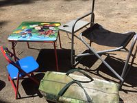 Kids table and chair set with folding chair and a green carrying bag, presumably for the tent.