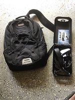 Black East Sport backpack with multiple zippered compartments, front elastic bungee cord detail, and carrying strap.