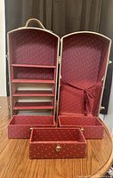 Open American Girl Samantha trunk showing multiple internal shelves, three drawers removed and arranged in front, lined with red patterned fabric.