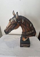 Side view of detailed horse bust statue showing bridle and mane highlights.