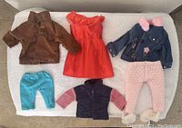 Clothes for medium size dolls including jacket, dress, pants, and denim jacket with pink pants