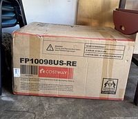 Closed cardboard box with Costway branding, model FP10098US-RE, showing shipping and handling information, unopened packaging.