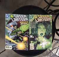 Two Green Lantern comic books issues #139 and #140 shown on a round table, covers vibrant with comic art