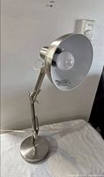 Photo of nickel coated adjustable desk lamp showing turned off lamp with light bulb visible