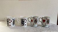 Four Queens China mugs shown upright, each decorated with different playing card faces (Kings and Queens of various suits).